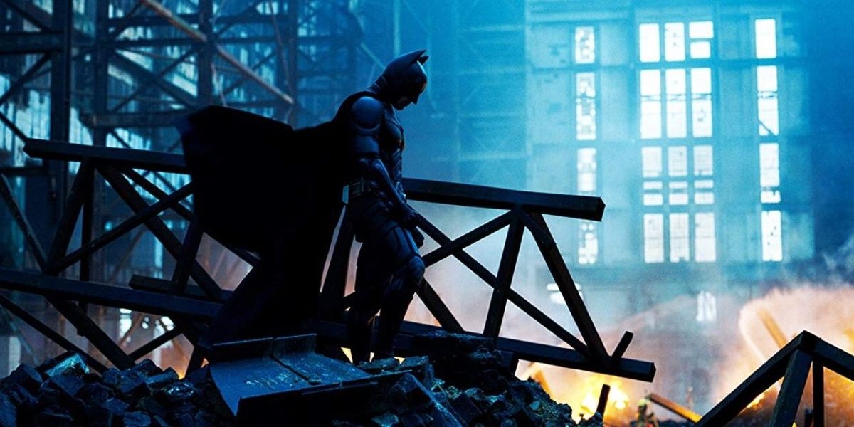 Batman silhouetted against the rubble of a destroyed building in The Dark Knight