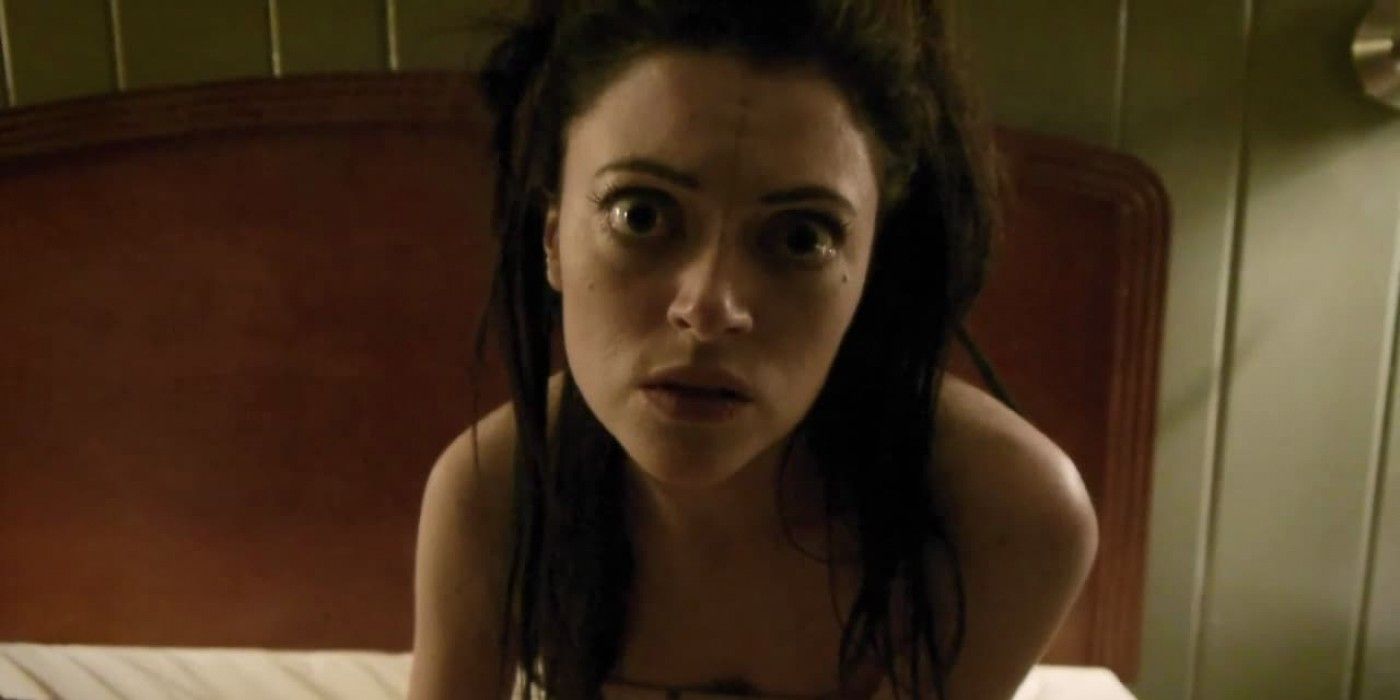 Hannah Fierman on a bed looking into a camera in V/H/S