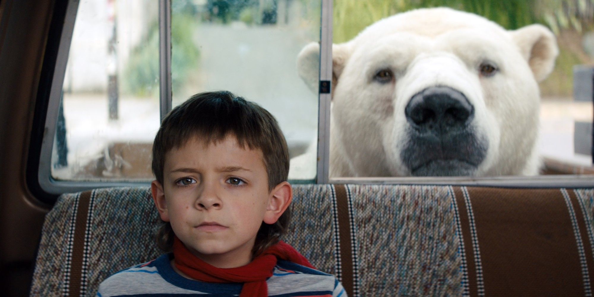 Winslow Fegley sitting on a bus seat with a polar bear in Timmy Failure