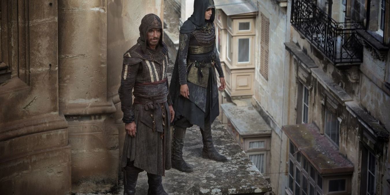 Two assassins stand on a ledge of a building in Assassin's Creed