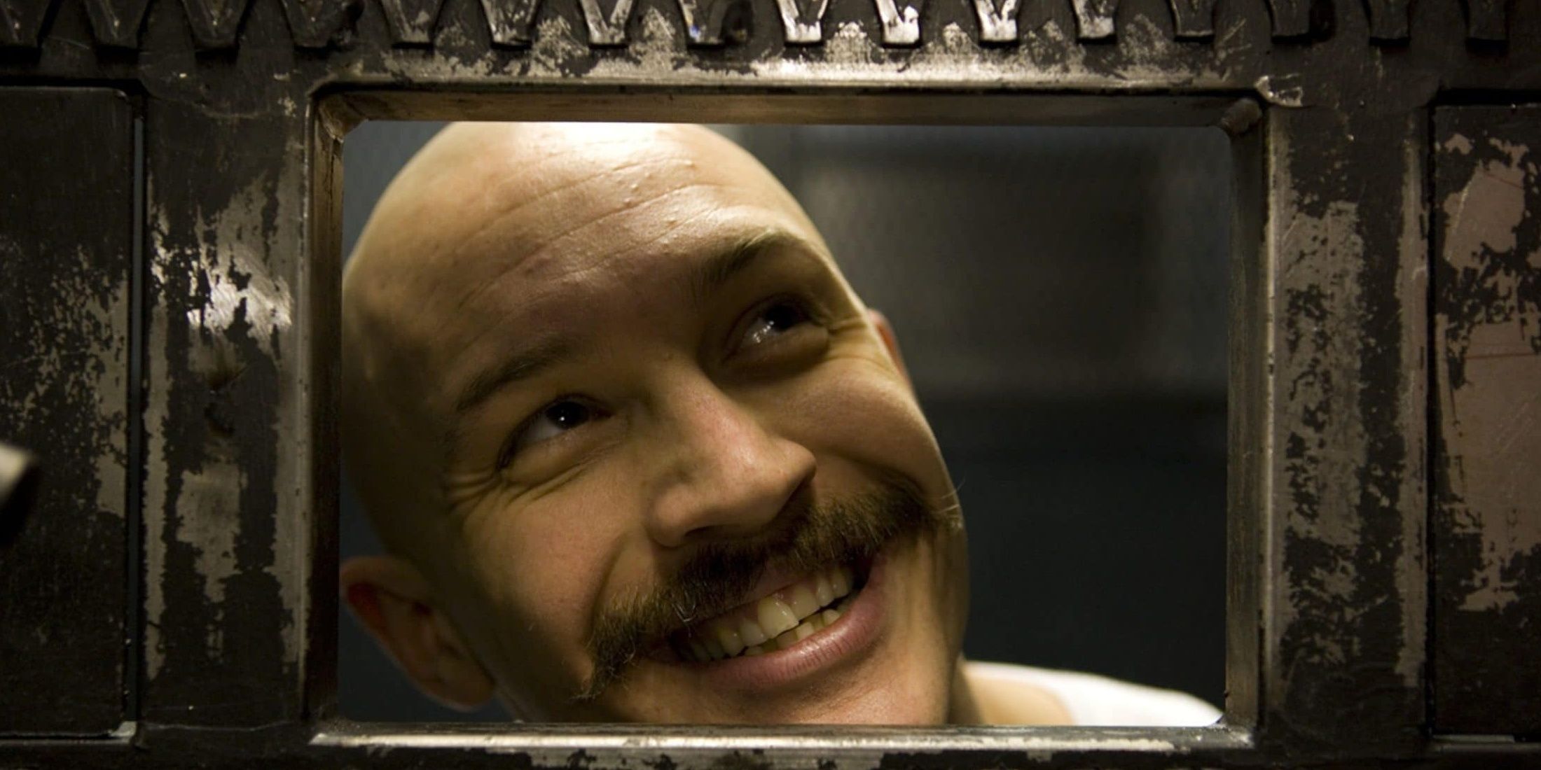 Bronson smiling through his cell window.