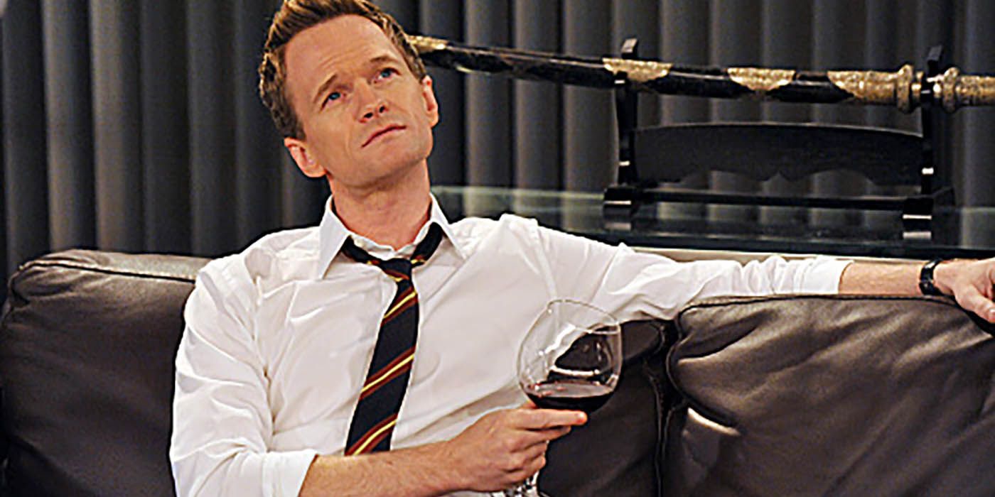 Barney sitting on his apartment counch with a drink in HIMYM