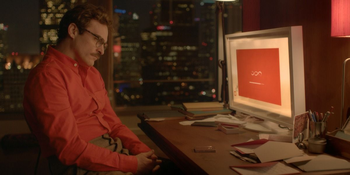 Joaquin Phoenix sits sadly in front of a computer