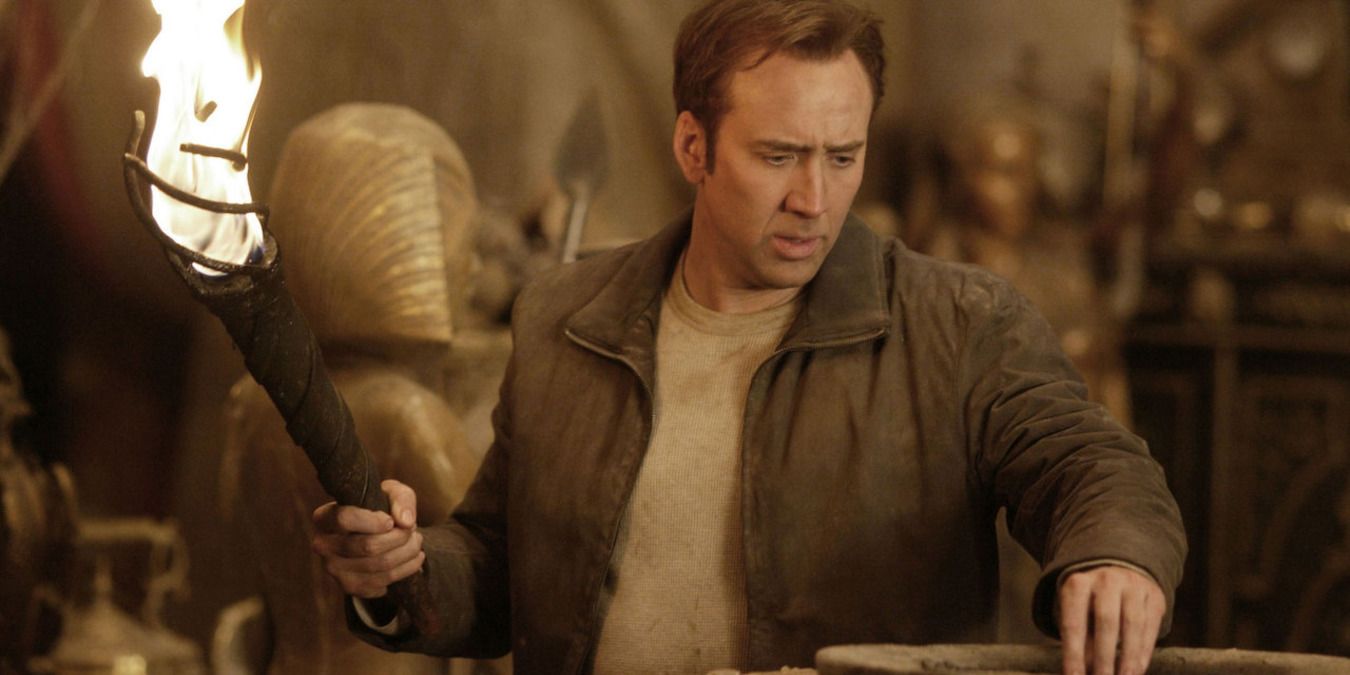 Nicolas Cage in holding. a torch and exploring underground in National Treasure