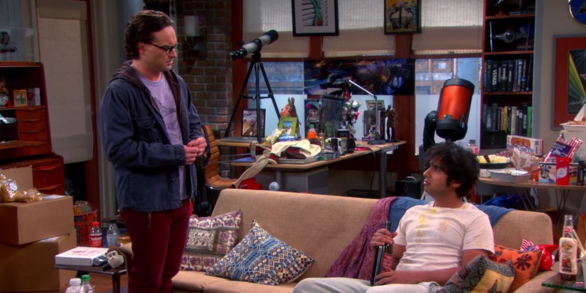raj sitting on a couch in a white tee and leonard standing near him in the big bang theory