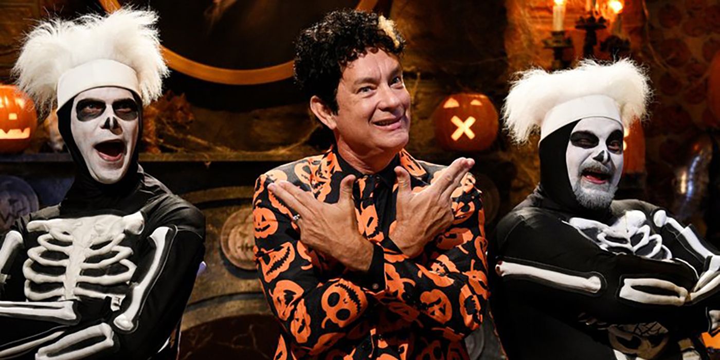 Tom Hanks poses with two skeletons in the David S. Pumpkins sketch from SNL