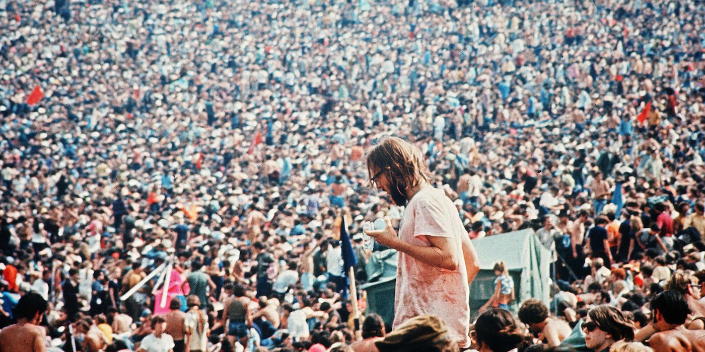 A screenshot of an artist on stage in front of a huge crowd in Woodstock