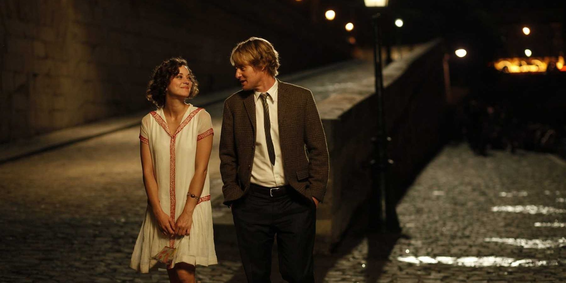 Adriana and Gil walking at night in Midnight in Paris