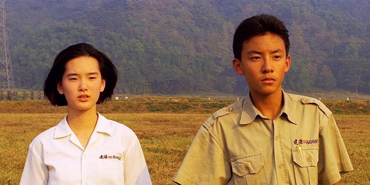 A girl and a boy standing in front of a field in A Brighter Summer Day