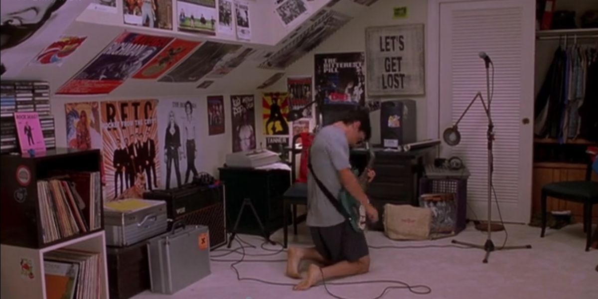 Cliff kneels in his room while playing guitar in Bring It On
