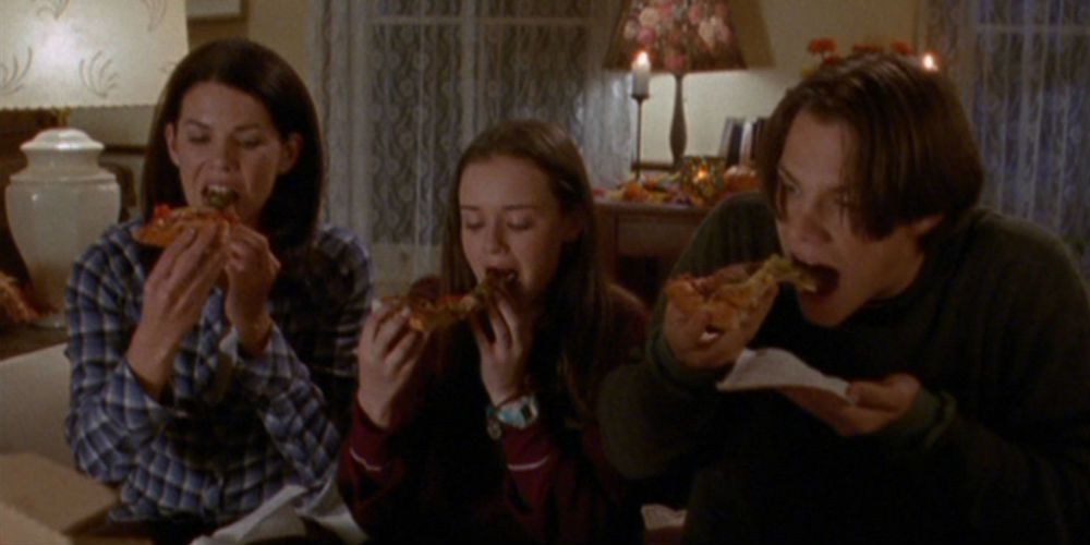 Lorelai, Rory, and Dean eating pizza on a movie night on Gilmore Girls