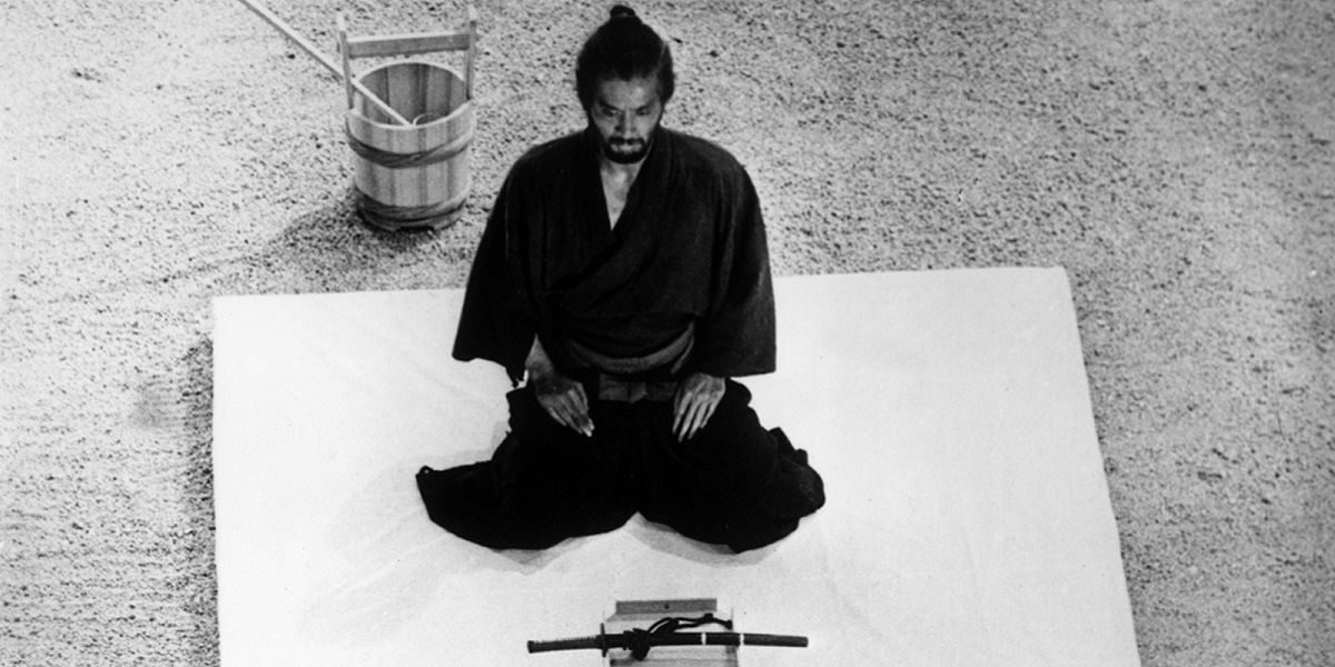 A man kneels in front of a sword in Harakiri.