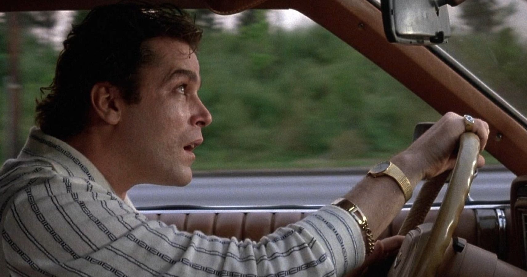 Henry Hill looks up in his car and checks for planes that are following him in Goodfellas