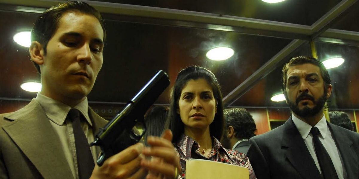 Ben holds a gun as Irene and Ricardo look on in The Secret in Their Eyes.