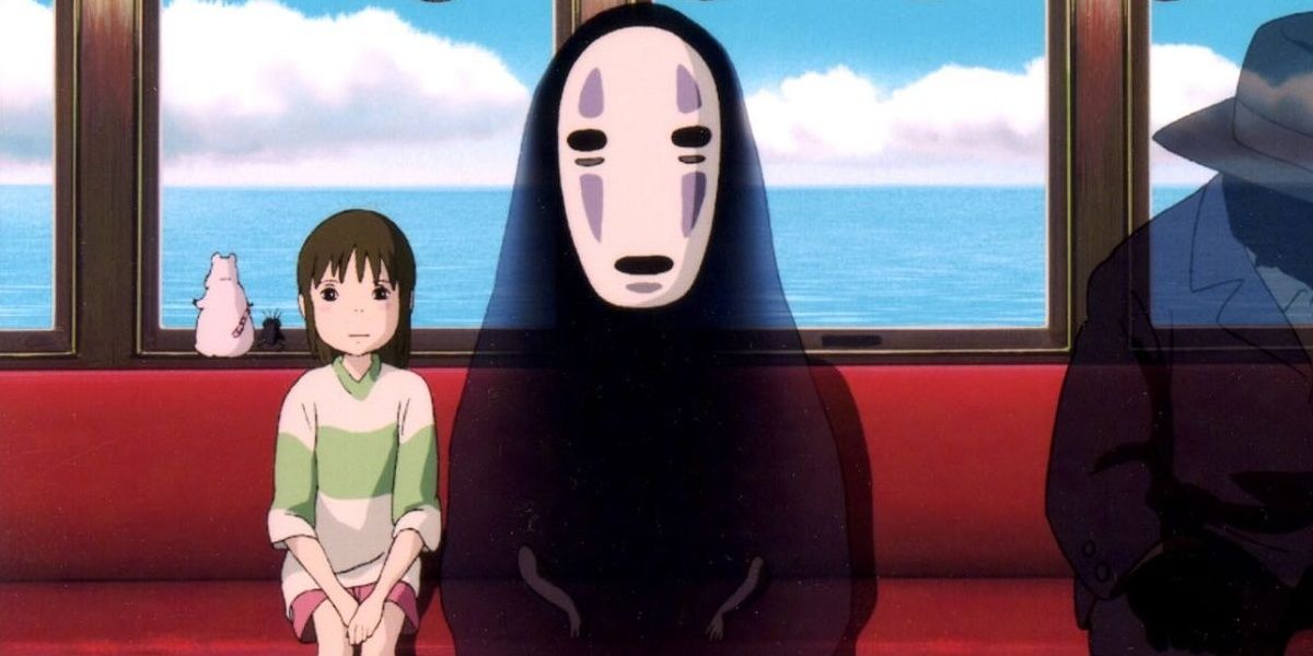 Chihiro sits next to No-Face on a train in Spirited Away.