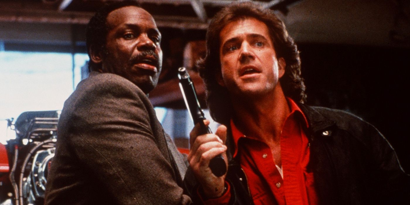 Riggs holds up a pistol while Murtaugh looks on in Lethal Weapon