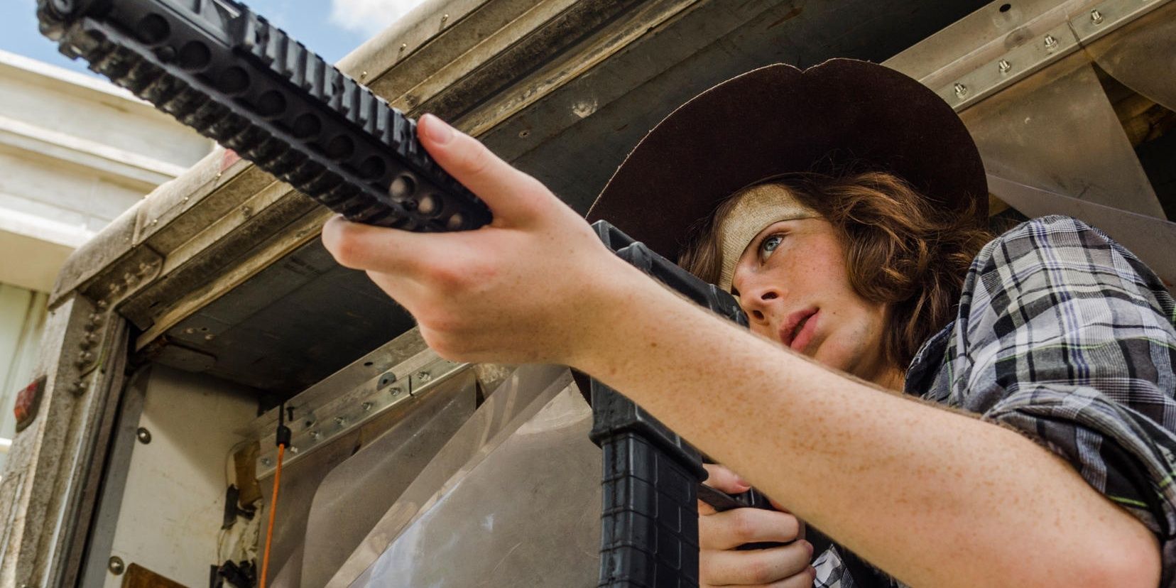 Carl aiming a gun at Negan on The Walking Dead.