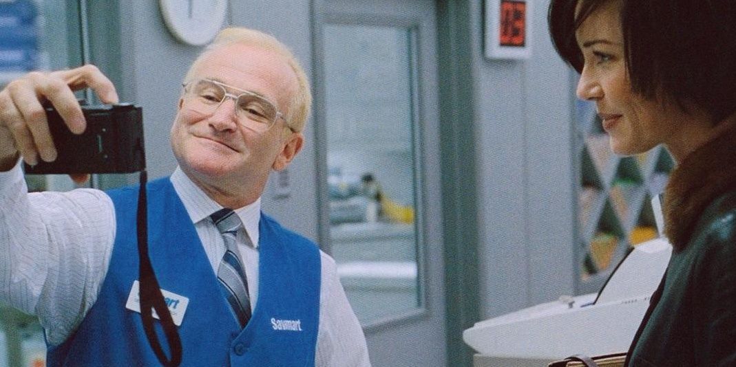 Robin Williams as Seymour "Sy" Parrish taking a photo with Connie Nielsen as Nina Yorkin in One Hour Photo