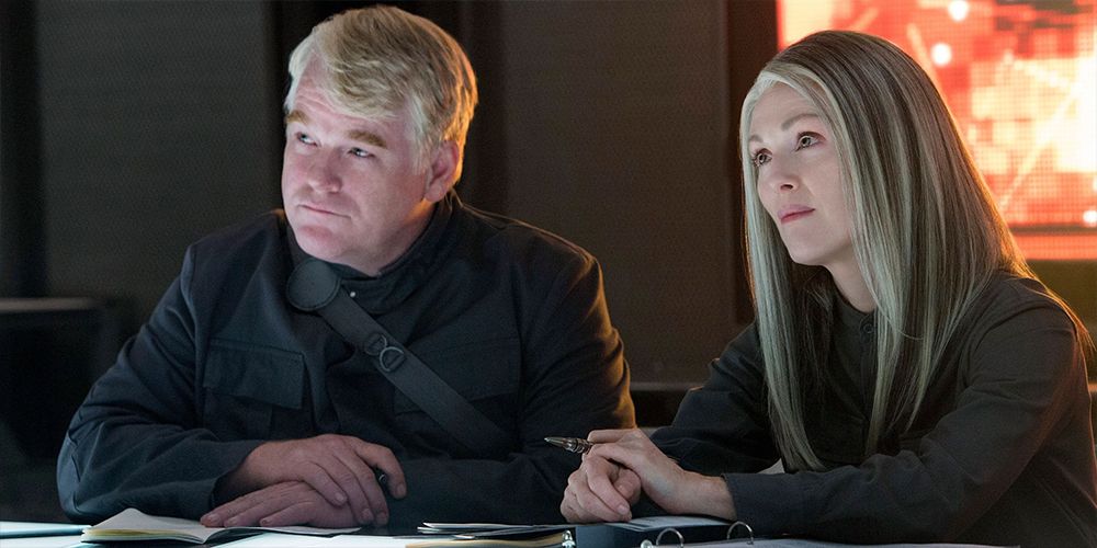 President Coin and Plutarch Heavensbee sitting together in The Hunger Games