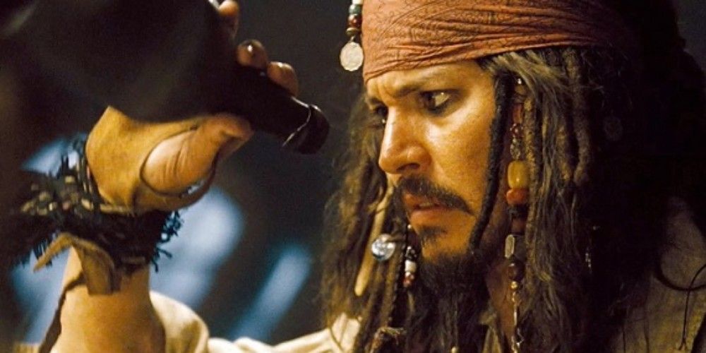 Jack Sparrow holding an empty bottle of run looking sad in Pirates of The Caribbean