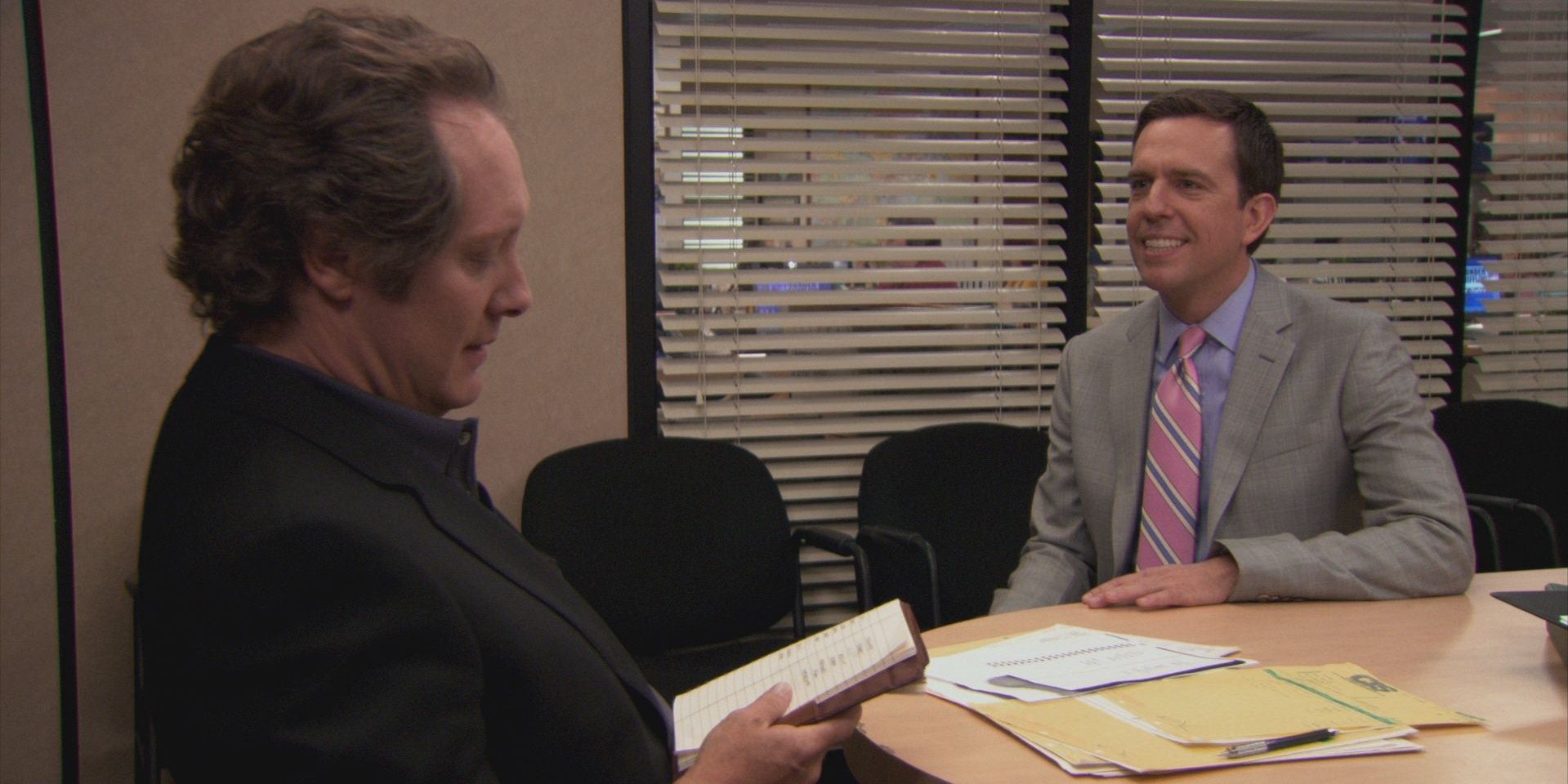 Andy Bernard and Robert California from the Office sitting in Conference Room and discussing about Winners and Losers List 