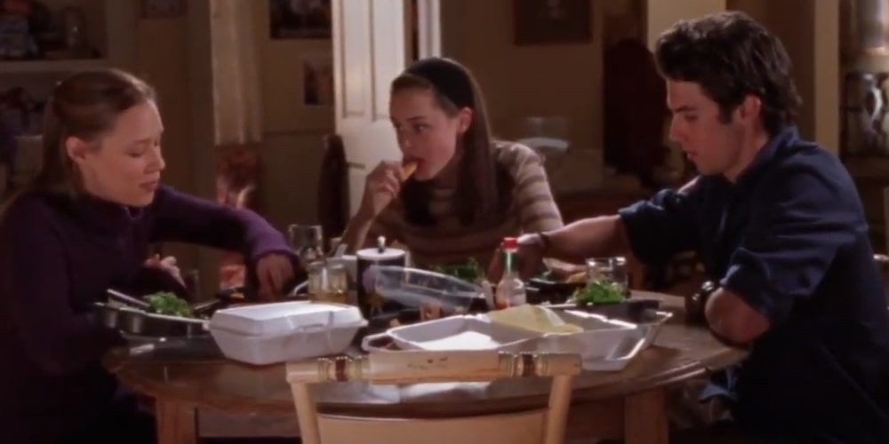 Paris, Rory, and Jess eating takeout food on Gilmore Girls