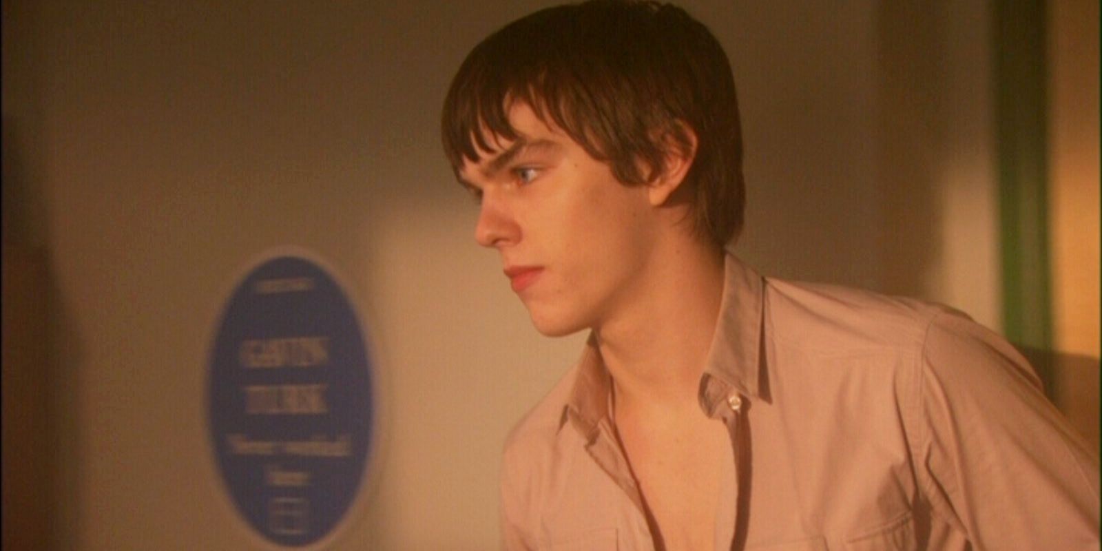 Tone Stonem from Skins putting a shirt on in a bedroom