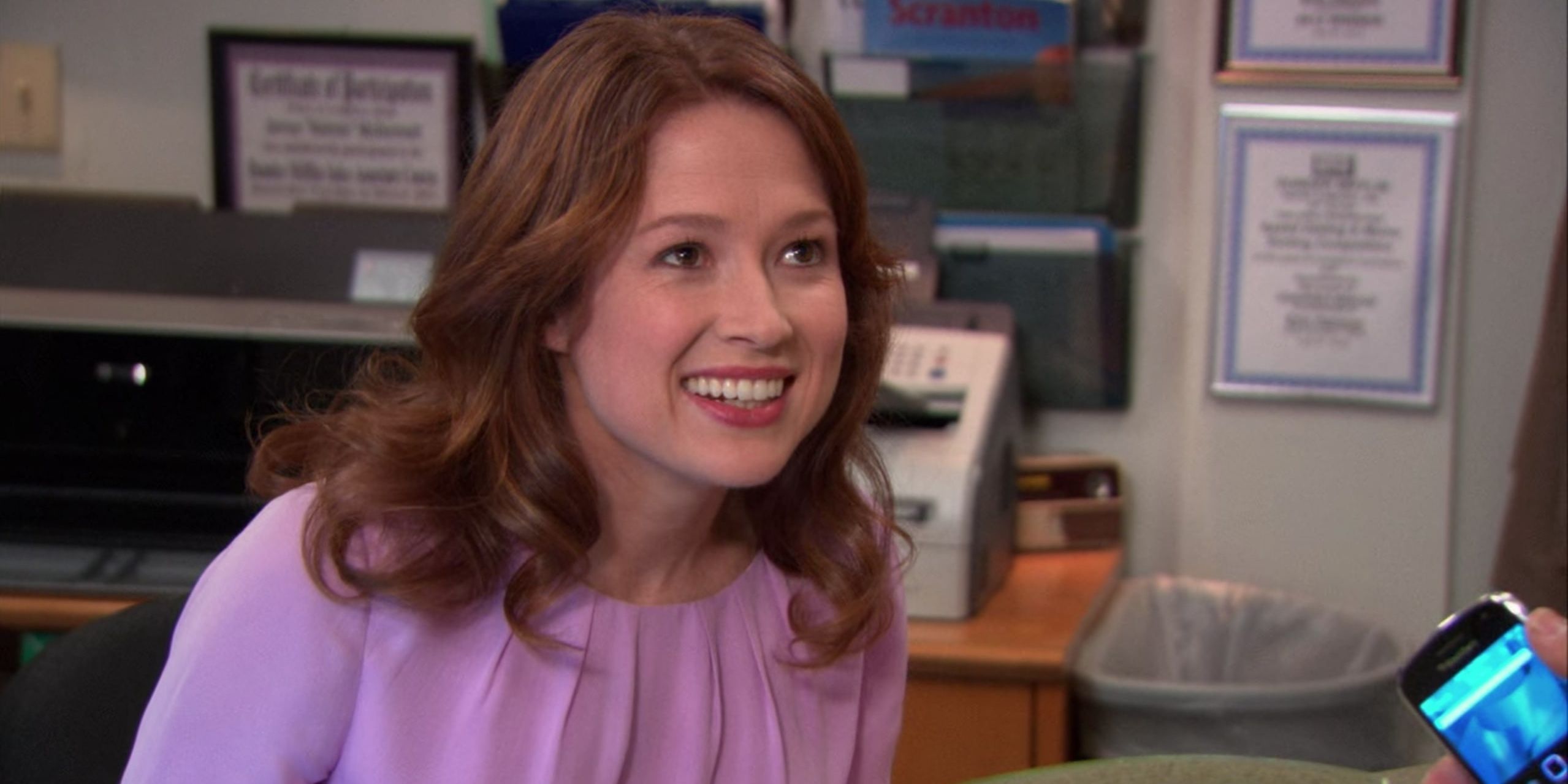 Erin Hannon smiling at someone at reception on The Office