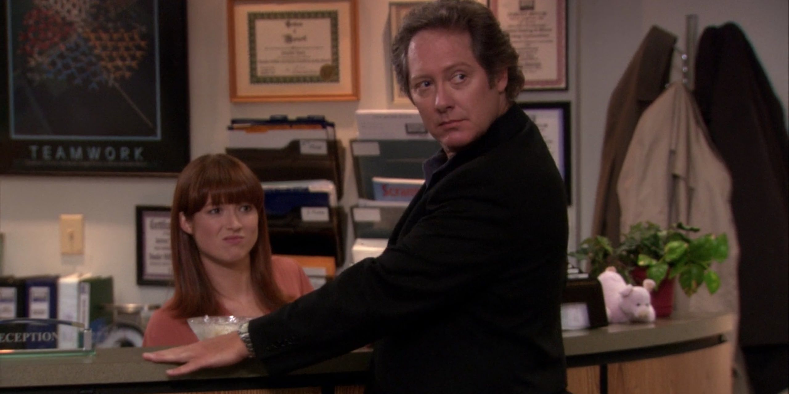 Robert speaks to Erin at the reception desk in The Office