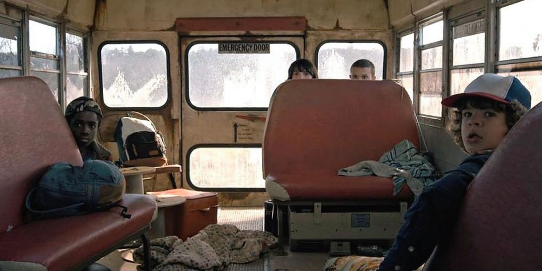 The Party members hide on an old schoolbus in Stranger Things Season 1