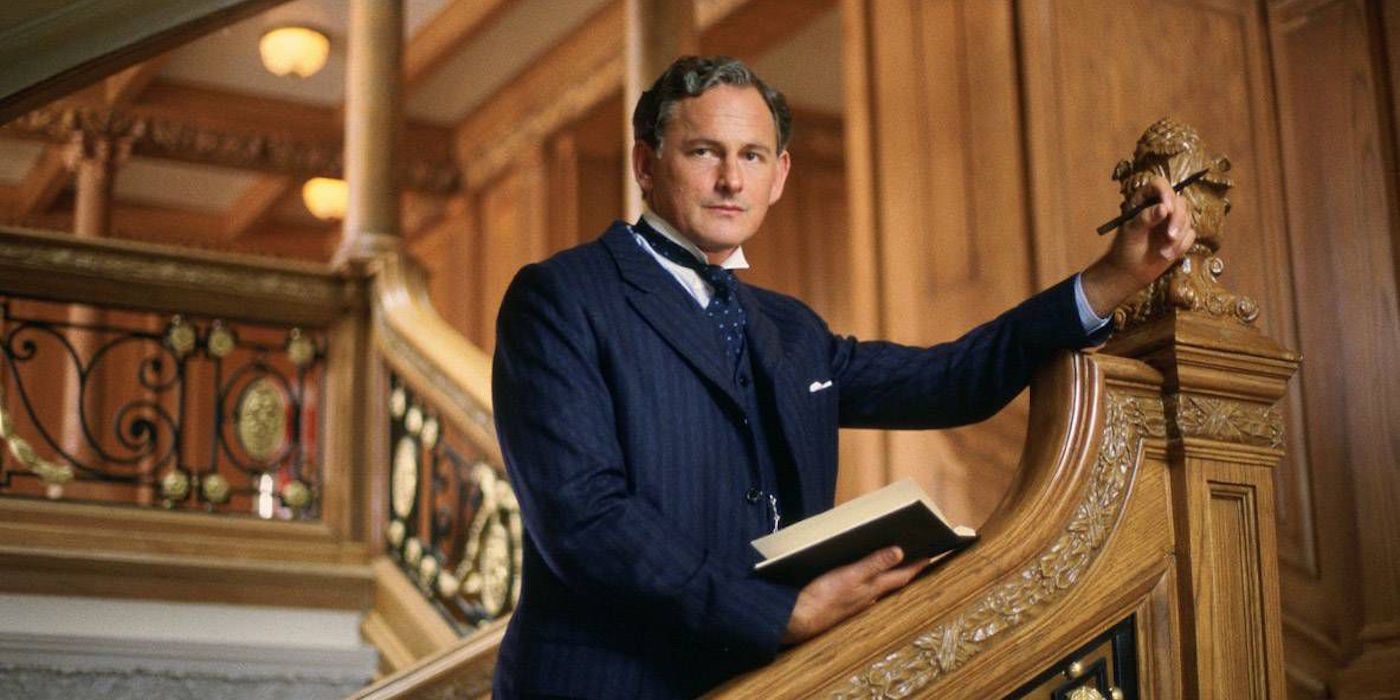 Thomas Andrews leans on a brown bannister in Titanic.