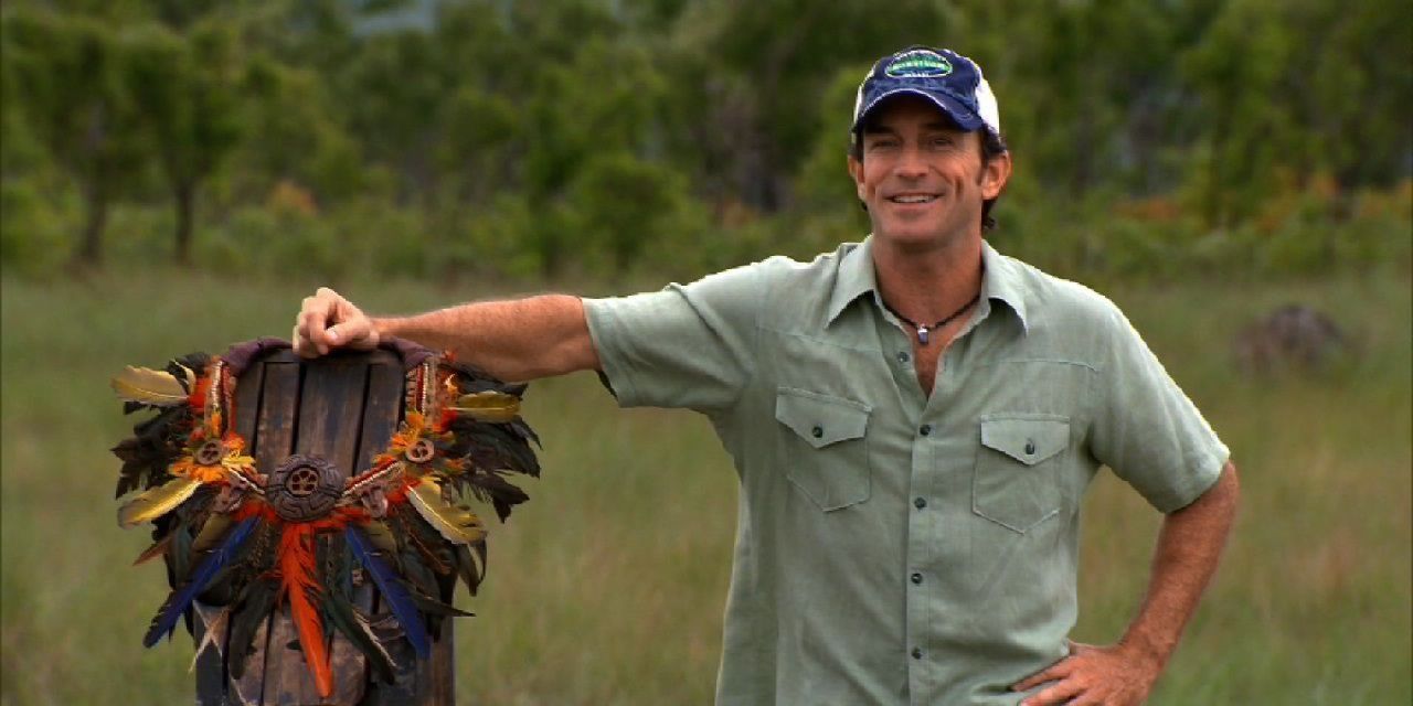 Jeff Probst stands next to the immunity necklace in Survivor: Tocantins