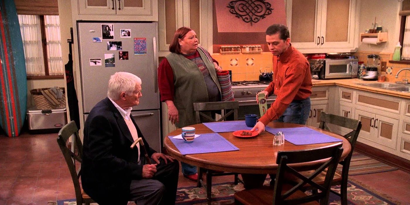 Alan (Jon Cryer) sets the table for an elderly man as Berta (Conchata Farrell) watches in Two and a Half Men