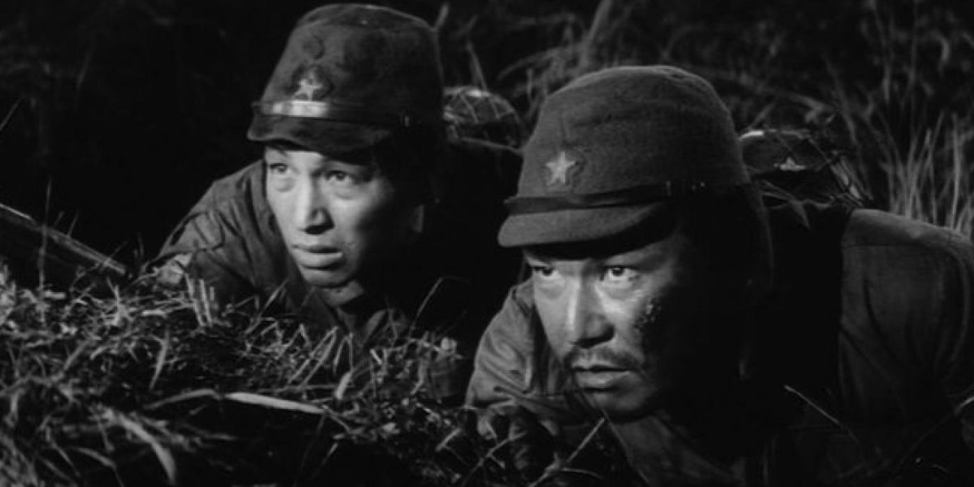 Two soldiers hiding in the grass in The Human Condition III: A Soldier’s Prayer.