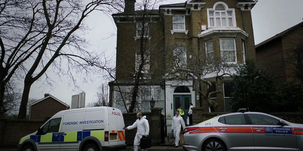 Police cars outside a house in What Remains