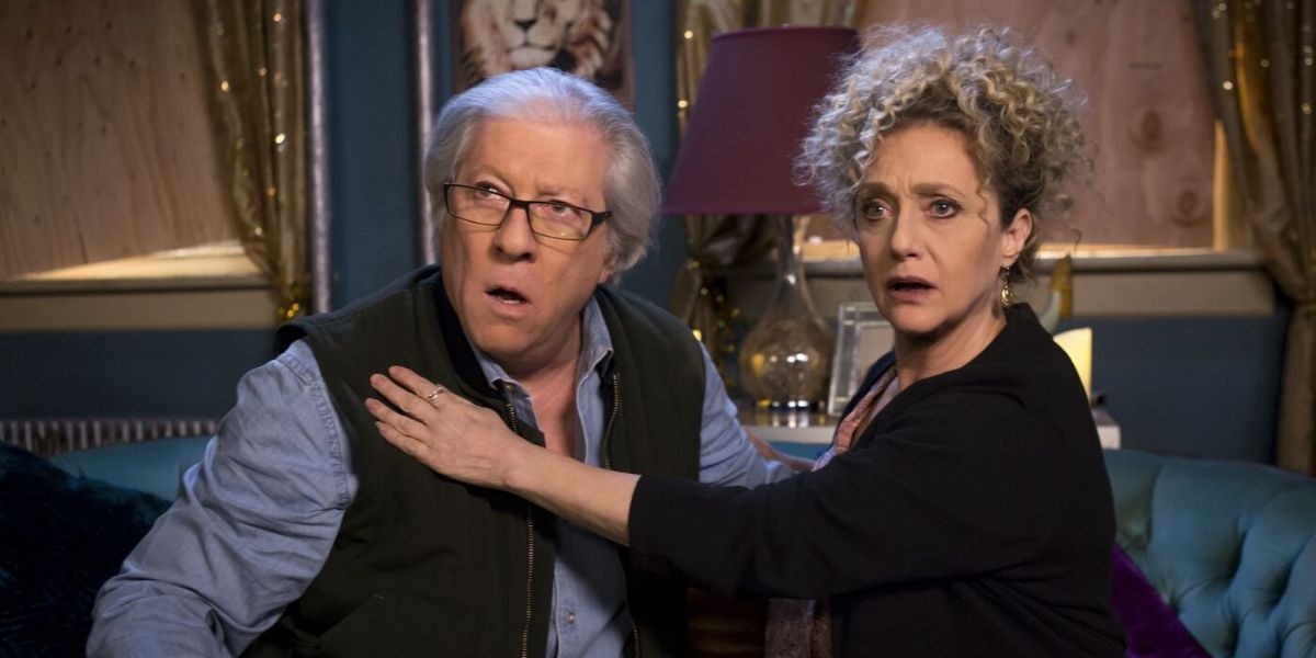 Artie Goodman and Lillian Kaushtupper embrace on the couch in Unbreakable Kimmy Schmidt