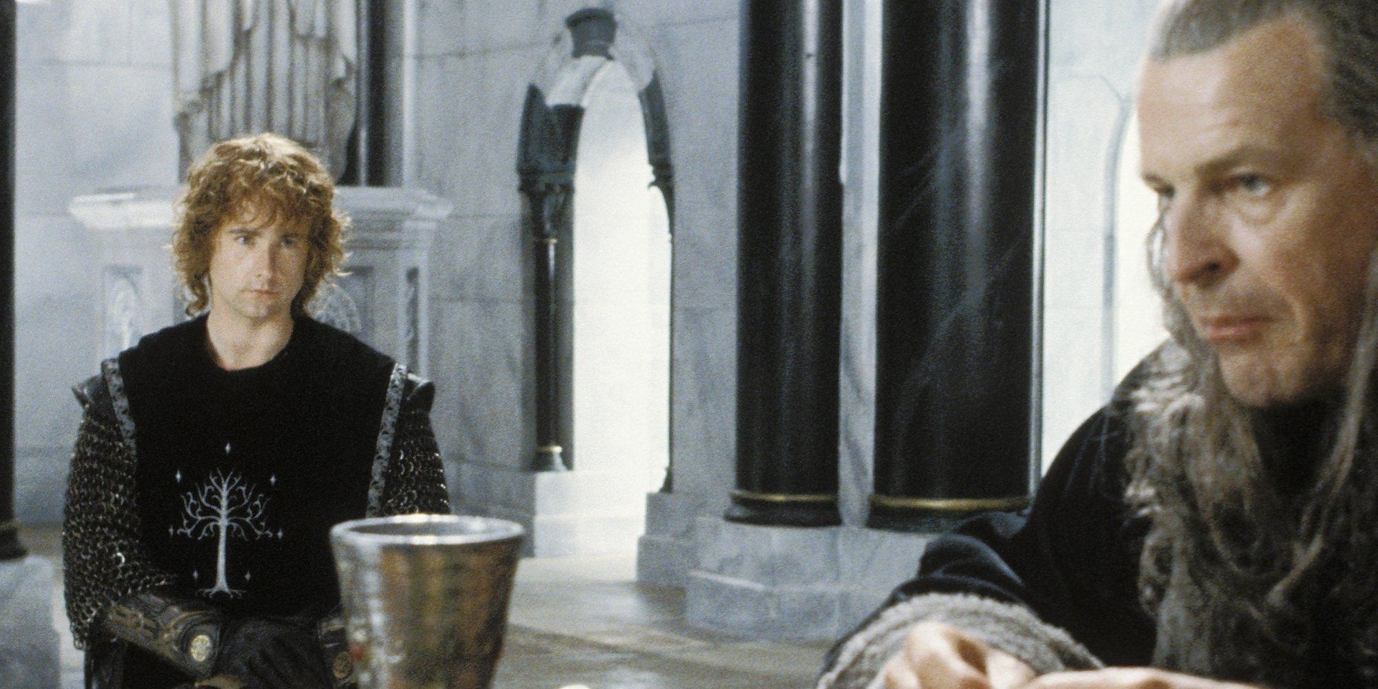 Pippin and Denethor sit at a table in Lord of the Rings