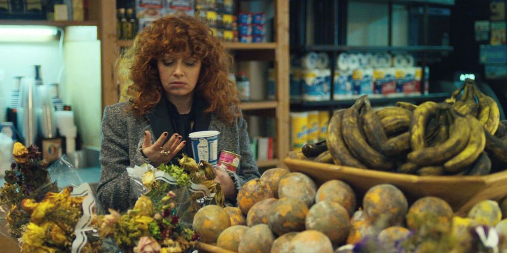 Nadia looking at her hand in the produce section of a store in Russian Doll.