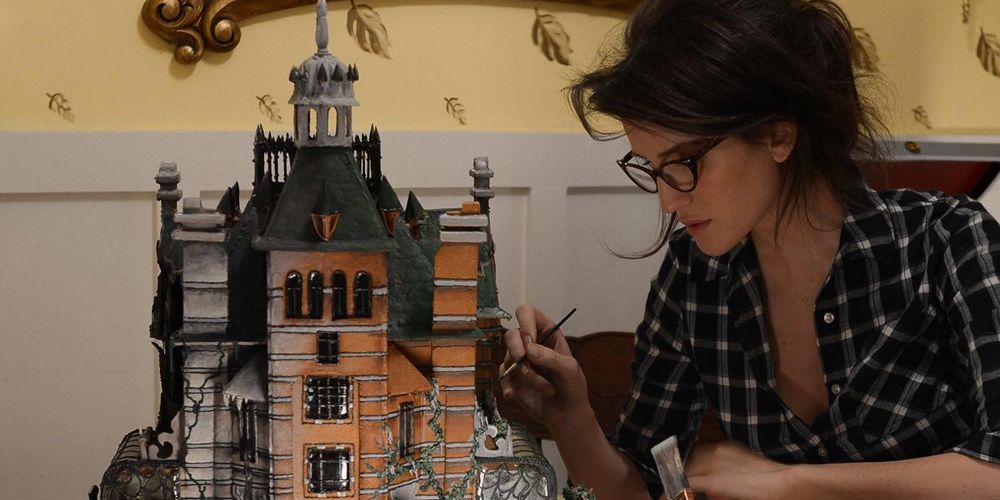 Christine painting a cake house in The Curious Creations Of Christine McConnell.