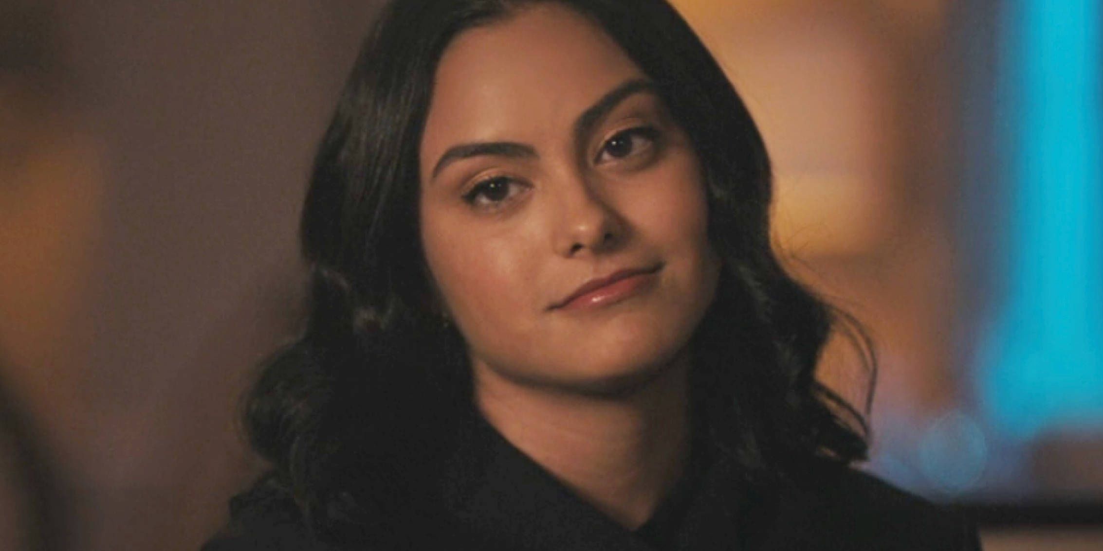 Veronica gives a small smile while tilting her head in Riverdale
