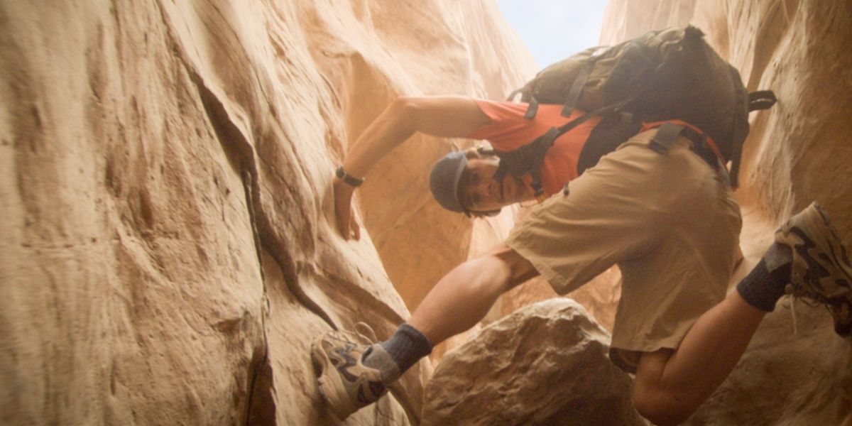 James Franco navigating a precarious part of the canyon in 127 Hours