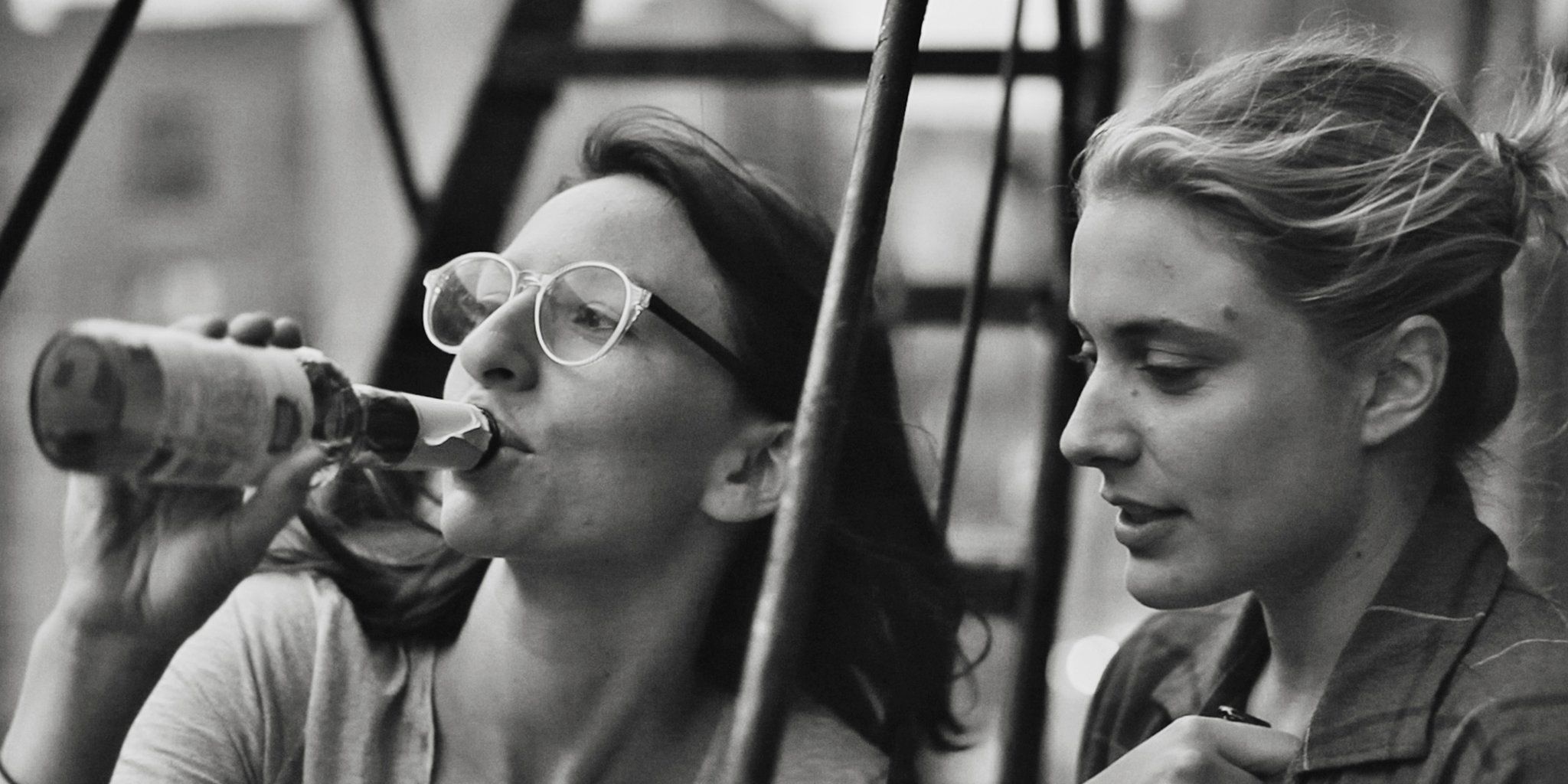 An image of Sophie and Frances drinking on a fire escape in Frances Ha.