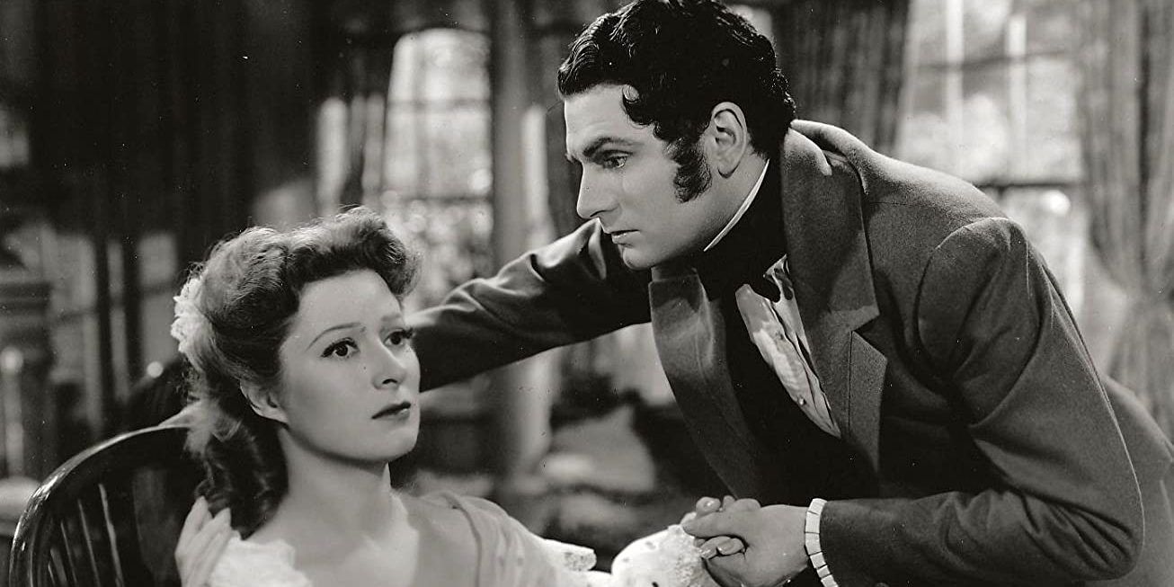 The stars of the 1940 Pride and Prejudice adaptation appear serious and lost in thought while holding hands