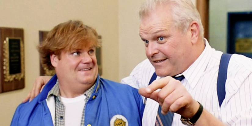Big Tom (Brian Dennehy) in Tommy Boy smiling and pointing next to Tommy (Chris Farley).