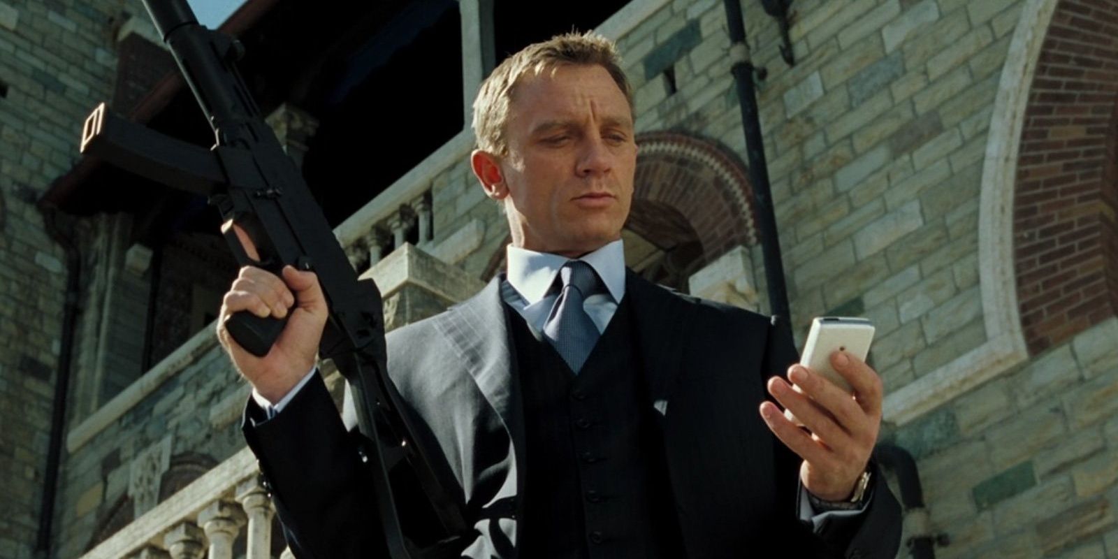 Daniel Craig with a machine gun and a cell phone in Casino Royale