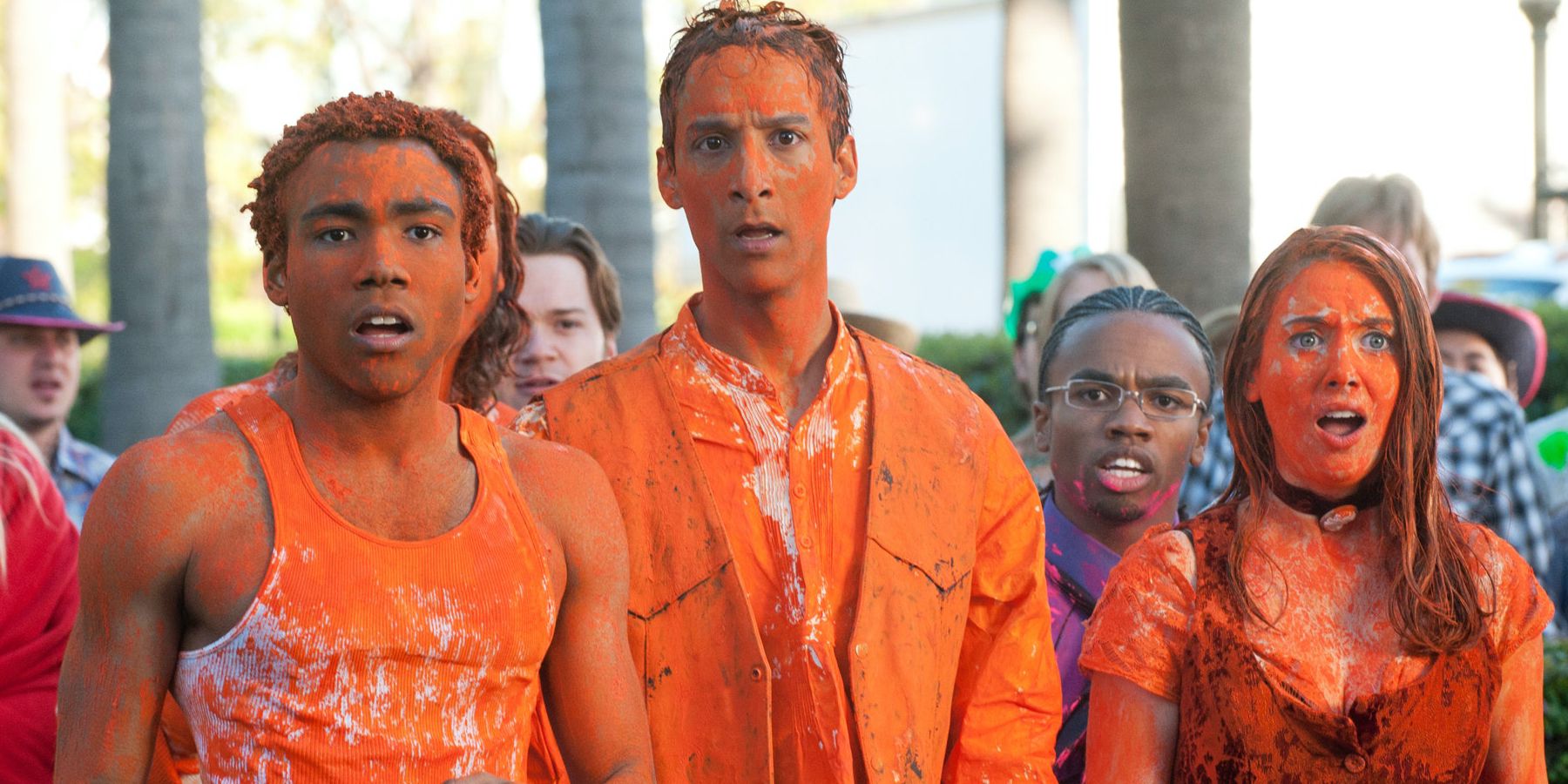 Troy, Abed y Annie están cubiertos de naranja en la comunidad.