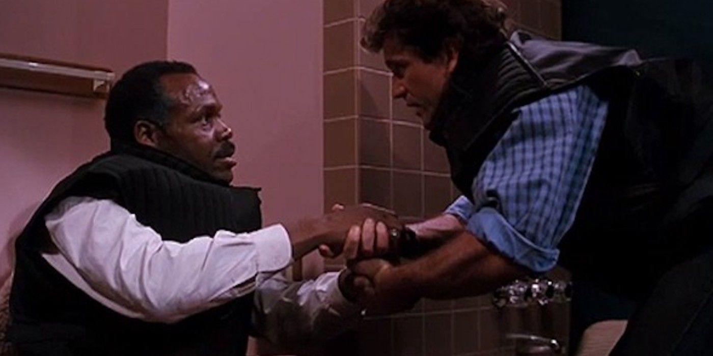 Danny Glover on a toilet rigged with explosives and Mel Gibson in Lethal Weapon 2