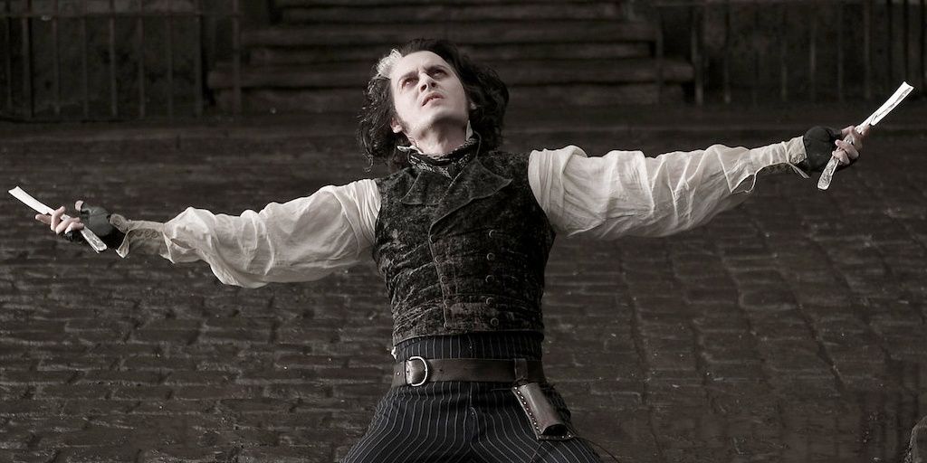 Johnny depp as sweeney todd with arms outstretched holding two razors