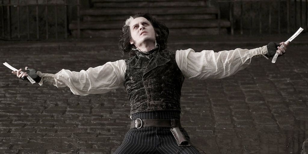 Johnny Depp como Sweeney Todd com os braços estendidos segurando duas lâminas de barbear