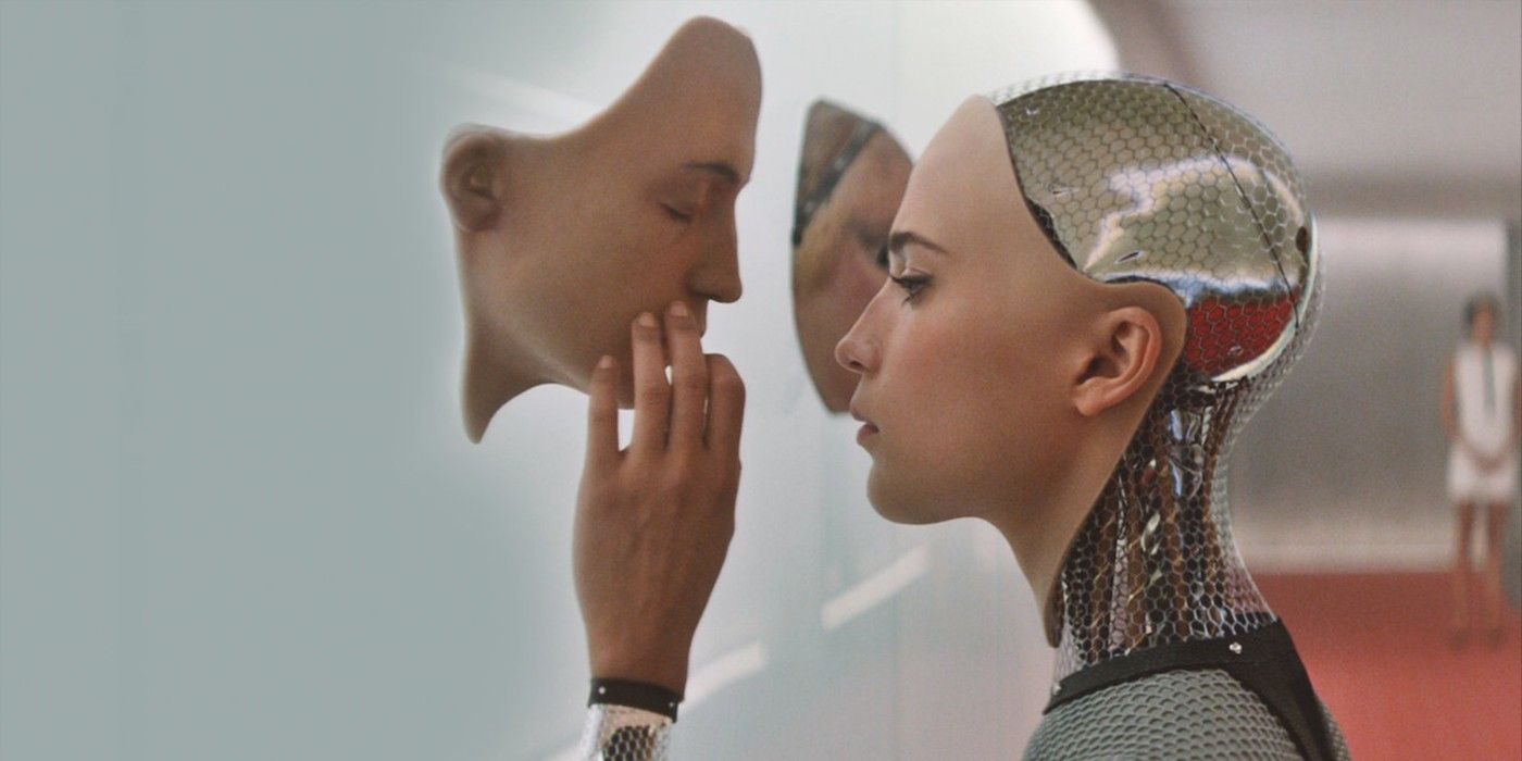 Ava looks at another android face in Ex Machina